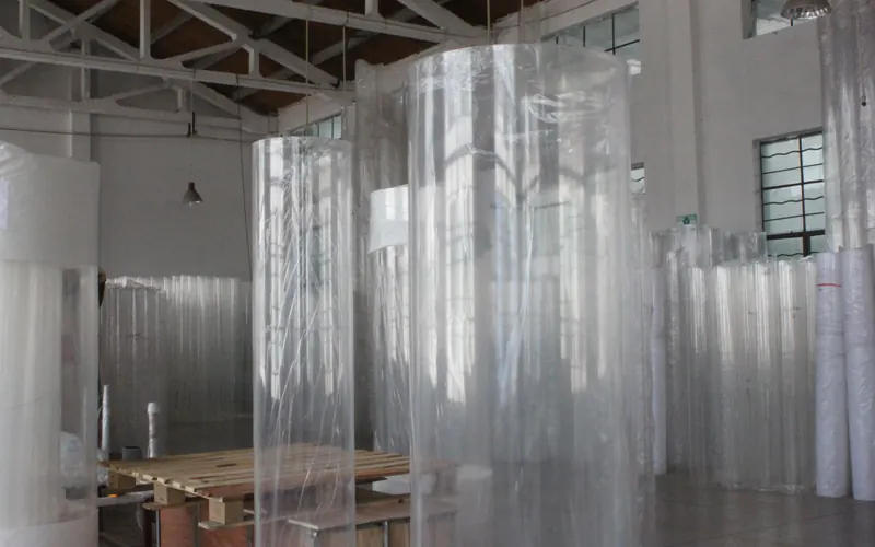 Row of large-diameter cast acrylic cylinders in the workshop