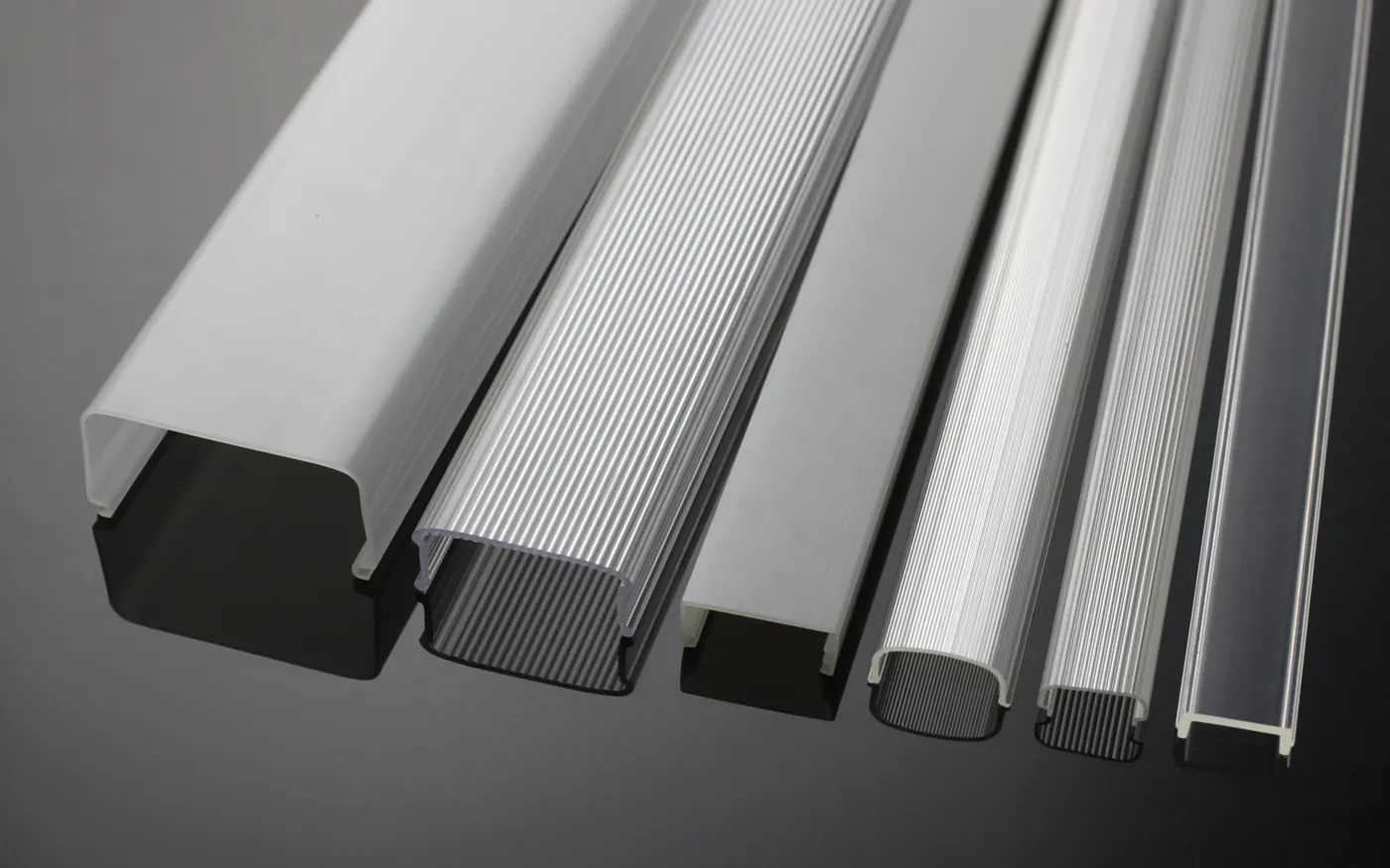 A range of extruded LED housing and diffuser cover profiles laid side by side