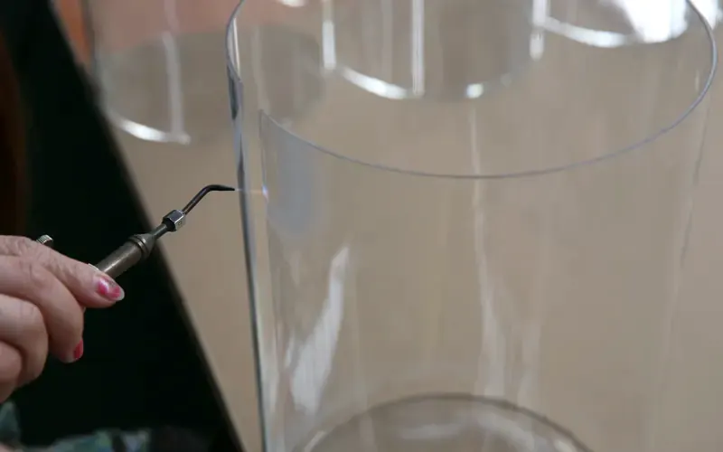 Flame polishing the cut edge of a clear acrylic tube